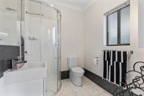 a bathroom with a toilet and a sink and a shower at Cadell Street Apartments Goolwa in Goolwa