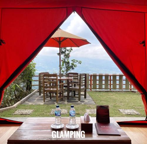 Kejajar的住宿－Bagas Luxury Camp，帐篷顶部一张桌子和两瓶水