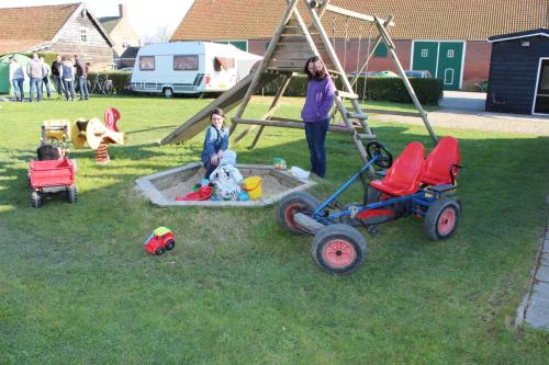 un grupo de niños jugando en un parque con juguetes en Caravan 't Koekoeksnest en Aagtekerke