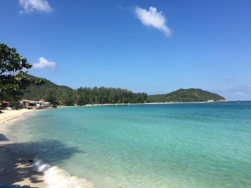 a view of a beach with blue water and trees at Mandalai Hotel in Chaloklum