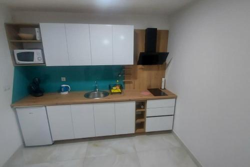 塞拉耶佛的住宿－Apartman Zana，小厨房配有白色橱柜和水槽