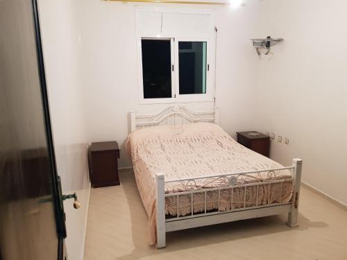 a bedroom with a bed and two night stands at Etage Villa Mehdia Amrya Plage N 277 in Kenitra