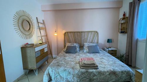 a bedroom with a bed and a dresser and a mirror at Mon ti Kaz Mon ti Bonheur in Saint-André