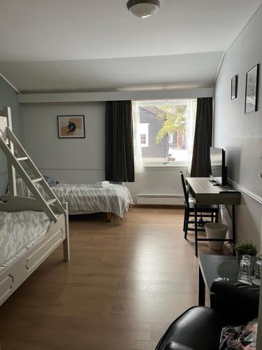 a bedroom with two bunk beds and a desk at Stor-Elvdal Hotell in Koppang