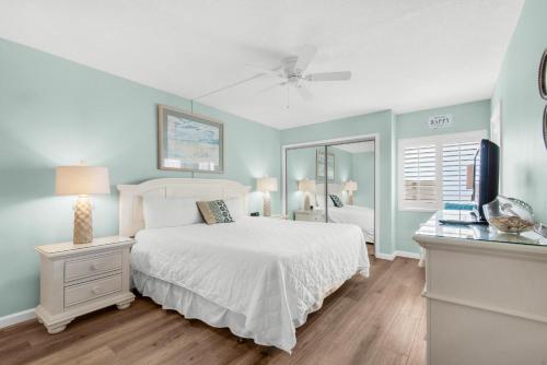 Schlafzimmer mit einem weißen Bett und einem TV in der Unterkunft Holiday Surf and Racquet Club 710 in Destin