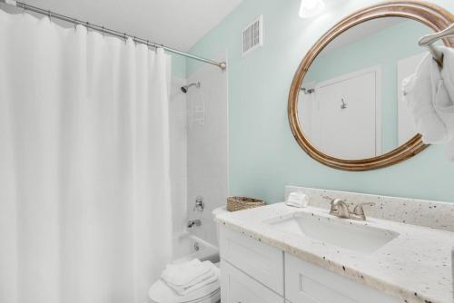 a white bathroom with a sink and a mirror at Holiday Surf and Racquet Club 710 in Destin
