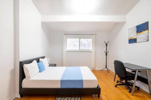 a bedroom with a bed and a desk and a computer at Harmony Home Near University of Waterloo in Waterloo