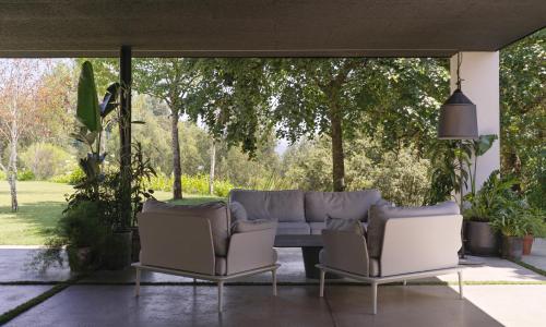 two chairs and a couch on a patio at Hotel Pepe Vieira in Raxo