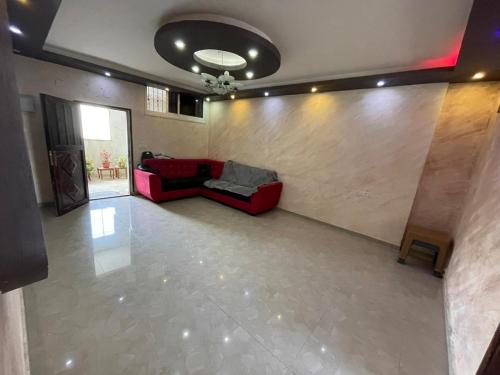 sala de estar con sofá rojo y pared en stay baitlahem en Bayt Jālā