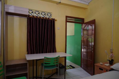 a room with a table and a chair and a bed at Omah Bogem Homestay Syariah in Randugunting
