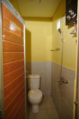 a bathroom with a toilet and a shower at Omah Bogem Homestay Syariah in Randugunting