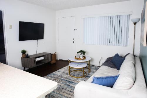 a living room with a white couch and a tv at Homey Oasis within minutes of San Diego adventures in San Diego
