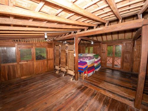 a large room with a bed in a wooden house at Villa Watu kodok - Villa Located Close to The Beach in Baron