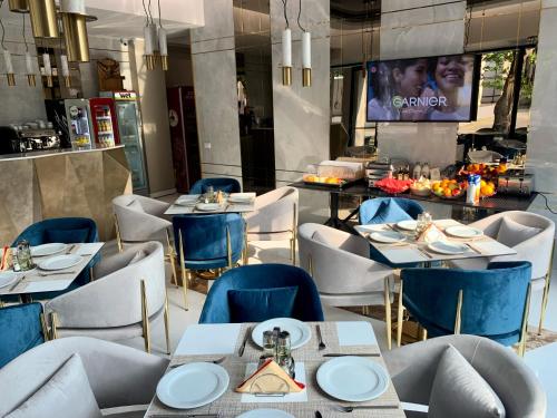a restaurant with tables and chairs and a tv at Onal Boutique Hotelier in Mamaia