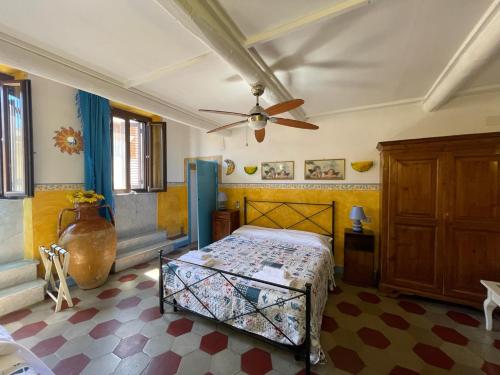 1 dormitorio con 1 cama y ventilador de techo en B&B Tony and Judy en Orbetello