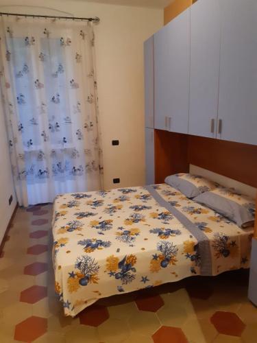 a bedroom with a bed with a floral bedspread at Brezza Marina in Portovenere