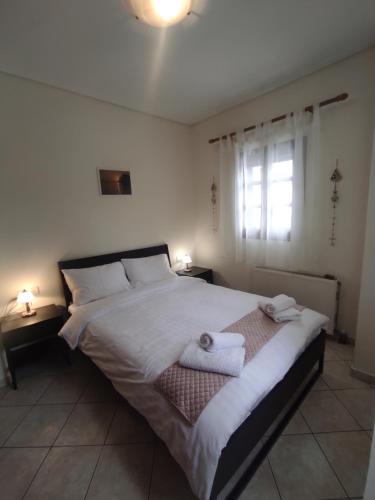 sypialnia z dużym łóżkiem z ręcznikami w obiekcie Evgenia's House w mieście Kala Nera