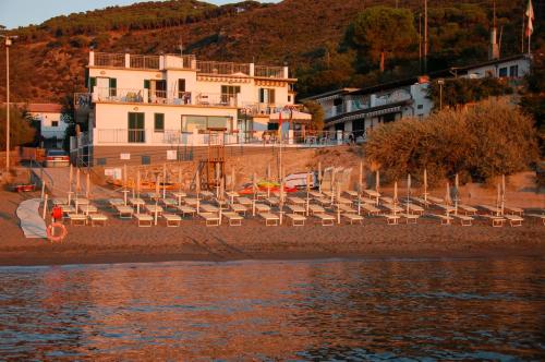 a group of chairs on a beach next to the water at Appartamenti Villa Miramare in Capoliveri