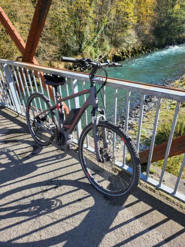 a bike parked on a bridge next to a river at La demeure aux Pins in Lourdes