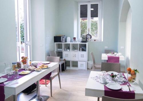 a dining room with a white table and chairs at Relais Villa Coppedè in Rome