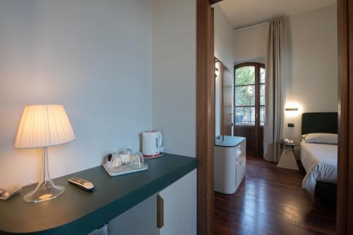 a hotel room with a bed and a table with a lamp at Hotel Gattapone in Gubbio