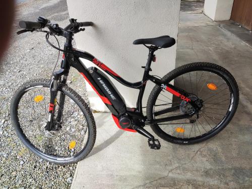 a bike parked next to a wall at La demeure aux Pins in Lourdes