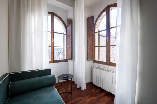 a living room with a couch and two windows at Hotel Gattapone in Gubbio