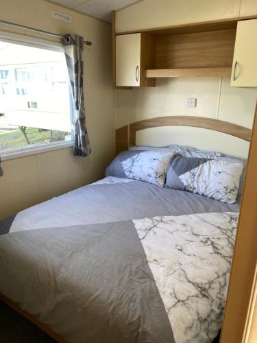 Porchfield的住宿－14 Greenwood Thorness Bay，一个小房间的一个床位,设有窗户