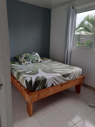 małe łóżko w pokoju z oknem w obiekcie Manate hebergement w mieście Faaa