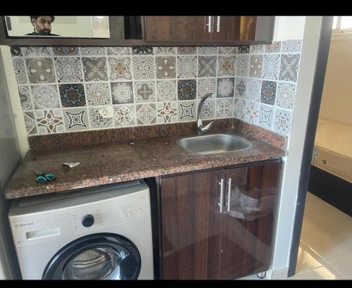 a kitchen with a sink and a washing machine at شاليه غرفتين بكريستال لاجونز جولف بورتو مارينا in El Alamein