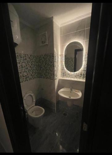 a bathroom with a toilet and a sink and a mirror at شاليه غرفتين بكريستال لاجونز جولف بورتو مارينا in El Alamein