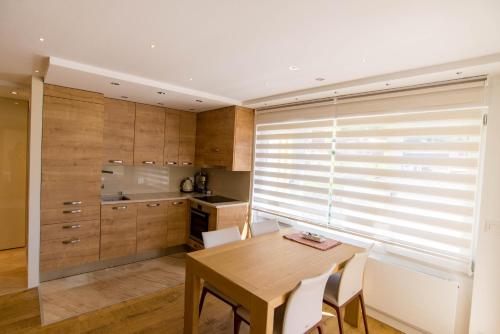 a kitchen with a wooden table and chairs and a window at Haus Cristal - 1441m in Leukerbad