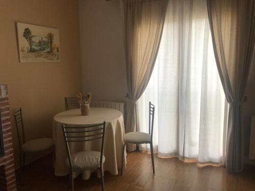 - une table et des chaises dans une chambre avec fenêtre dans l'établissement Aire de valsain, à La Pradera de Navalhorno