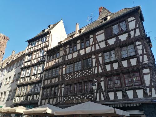 a tall building with windows and umbrellas in front of it at A la Tour des Rohan in Strasbourg