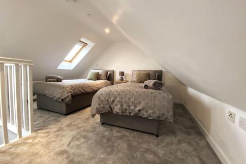 a attic bedroom with two beds and a skylight at 3bed house with Parking short walk to Bath centre in Bath