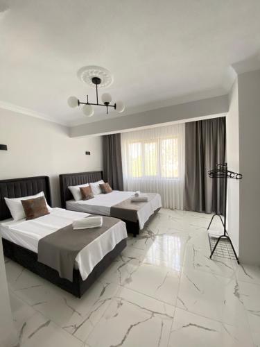 a hotel room with two beds and a chandelier at Bavella House in Pamukkale