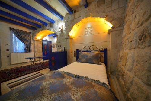 a bedroom with a bed in a stone wall at Alaturca House in Göreme