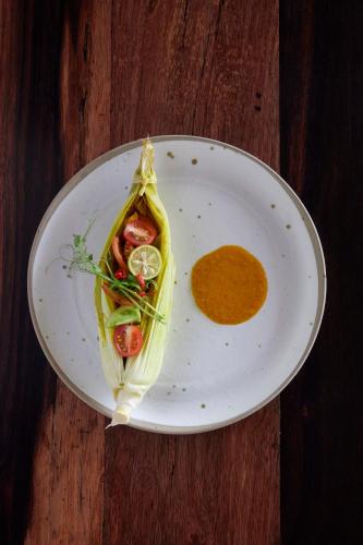 a white plate with a dish of food on a table at Innit Lombok in Ekas