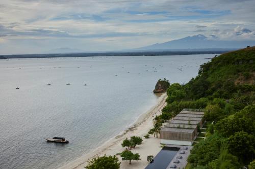 an aerial view of a beach with a boat in the water at Innit Lombok in Ekas