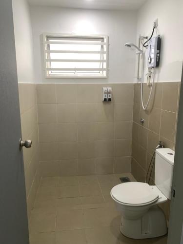 a bathroom with a toilet and a phone on the wall at Sutra Damai in Kampung Saberang Balok