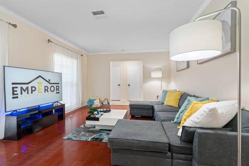 a living room with a couch and a tv at Spacious & Amazing Home w/ Big Pool and Patio in Brandon