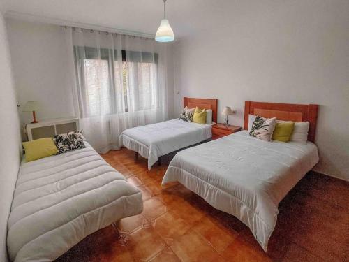 - une chambre avec 2 lits et des draps blancs dans l'établissement casa patricia, à Pontevedra