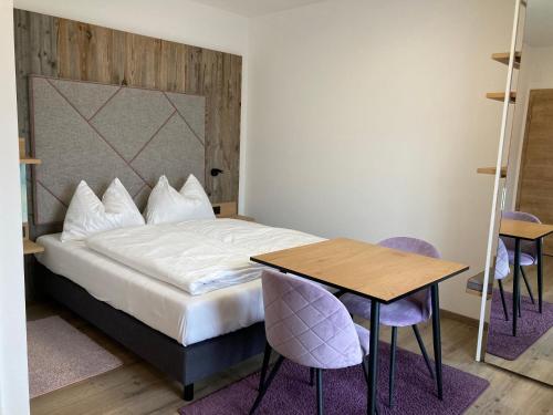 a bedroom with a bed and a table and chairs at Hotel Seerose Wolfgangsee in St. Wolfgang