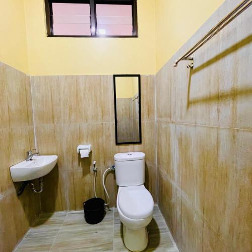 a bathroom with a toilet and a sink at Teras Seroja Homestay in Wonosobo