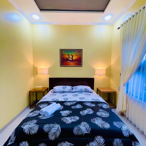 1 dormitorio con 1 cama con edredón azul en Pelataran Seroja Villas, en Wonosobo