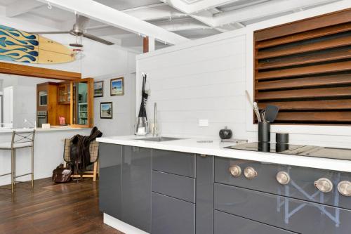 a kitchen with gray cabinets and a counter top at Belle Escapes Tropical Haven Holiday Home Palm Cove in Palm Cove