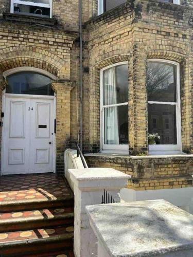 Casa de ladrillo con puerta blanca y ventanas en Bright & Relaxing Studio in Brighton & Hove en Brighton & Hove