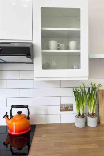 an orange tea kettle on a stove in a kitchen at Bright & Relaxing Studio in Brighton & Hove in Brighton & Hove