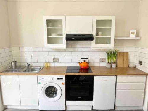 a kitchen with a sink and a washing machine at Bright & Relaxing Studio in Brighton & Hove in Brighton & Hove