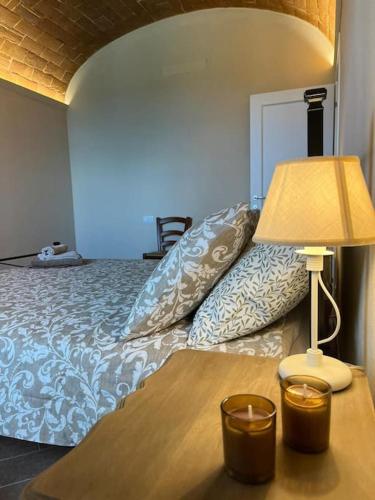 a bedroom with a bed and a table with a lamp at Sangi Chianti Vacations in Poggibonsi